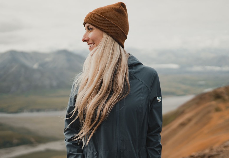 A woman wearing Stretch Voyagr jacket with backcountry in the background