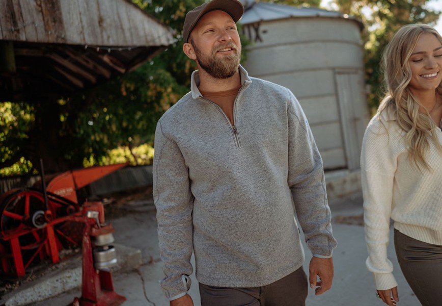 A man wearing a fleece fall jacket in nice weather