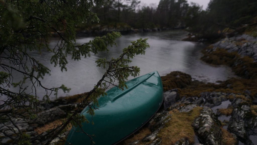 Green kayak on rocky river