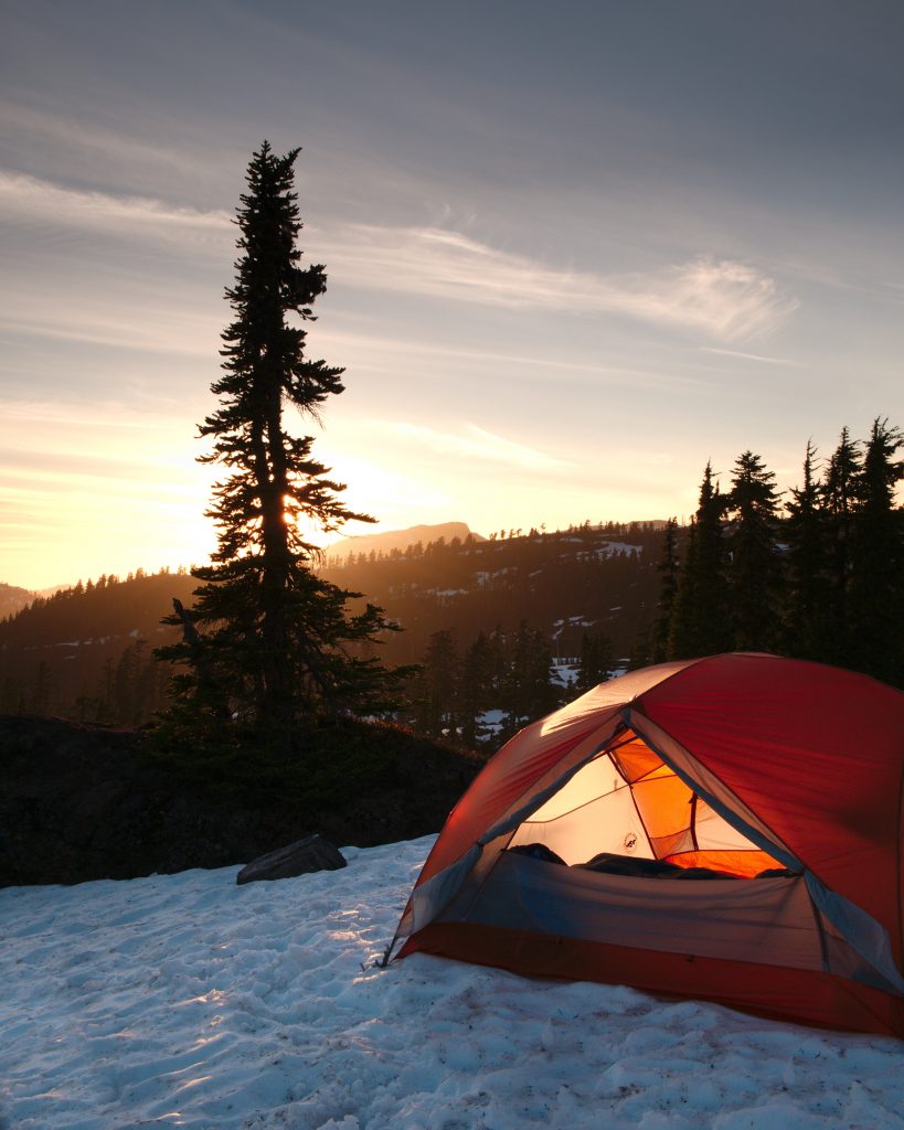 Preparing for Winter in the Backcountry FI An orange dome tent near trees during sunrise