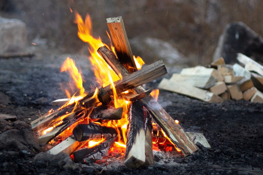 Flames of teepee campfire at campsite