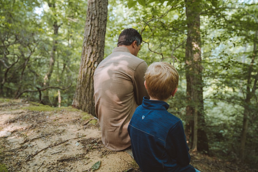 Forest Therapy - Father and son resting in the forest dressed in KUHL Clothing.