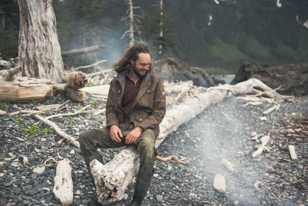 Lessons from Dad - a man sitting on a tree stump, next to a smoky ground