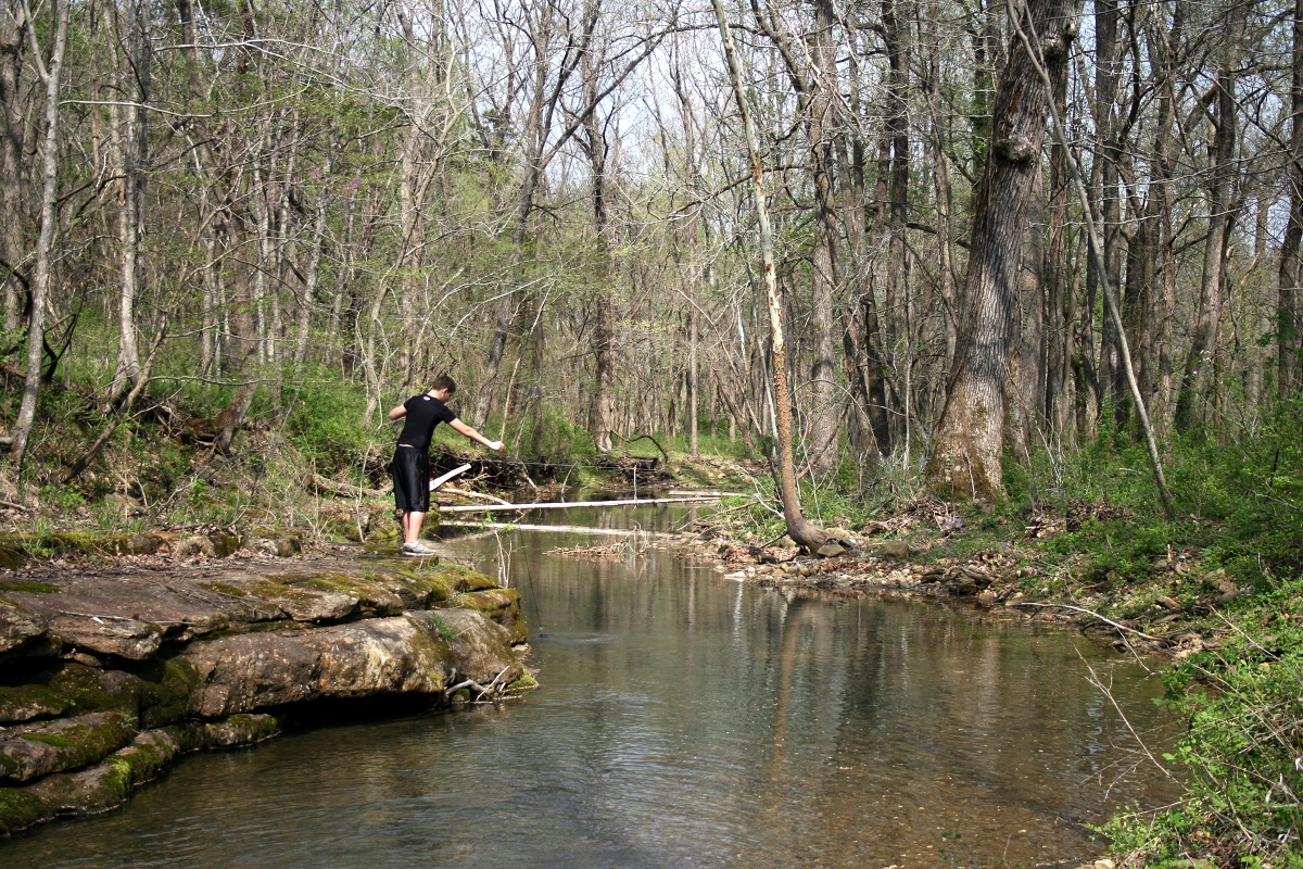 boy holding fishing line over body of water