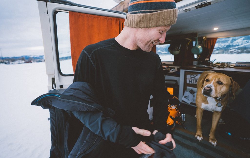 man and dog in van with snowy background