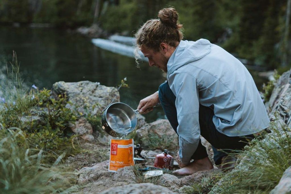 man in gray shirt holding water pot outdoors