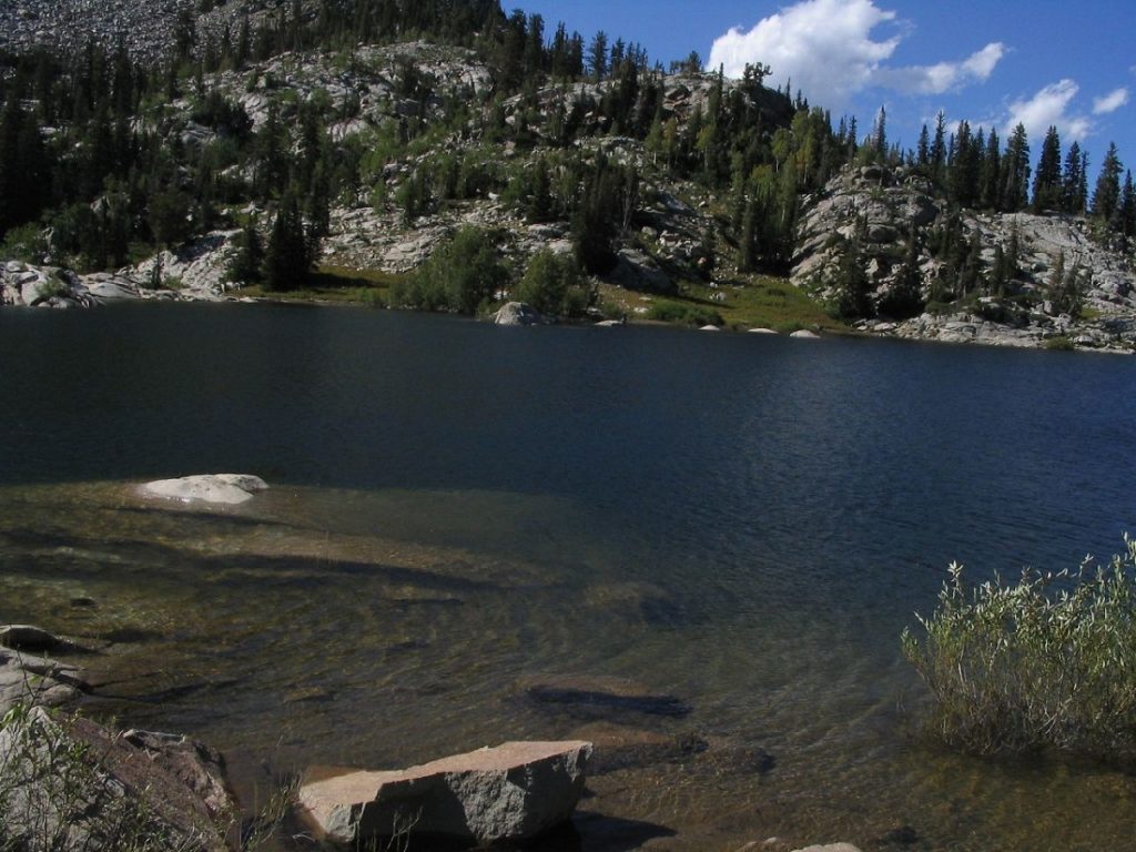 blue body of water with rock formations in the background