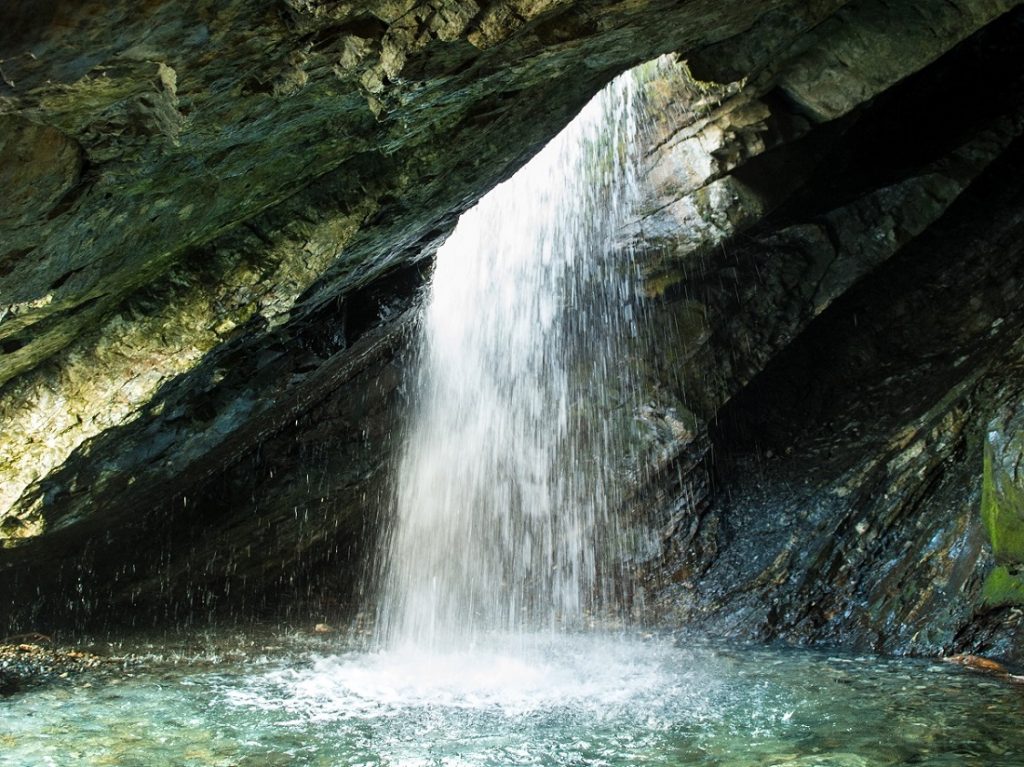 water falling from rocks into body of water