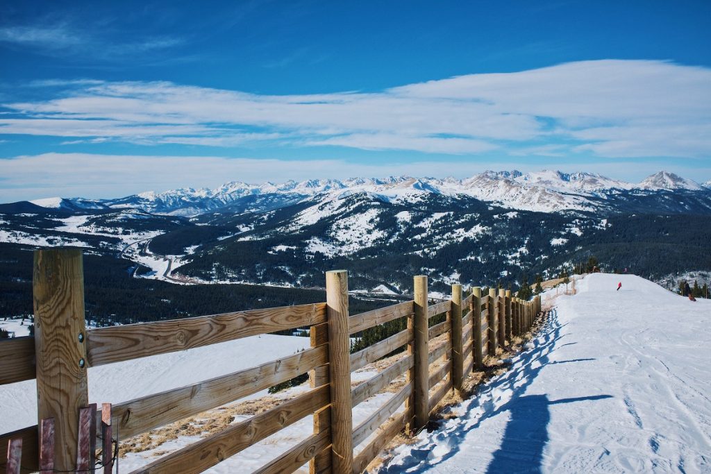 snowfield and brown wooden fence near mountain