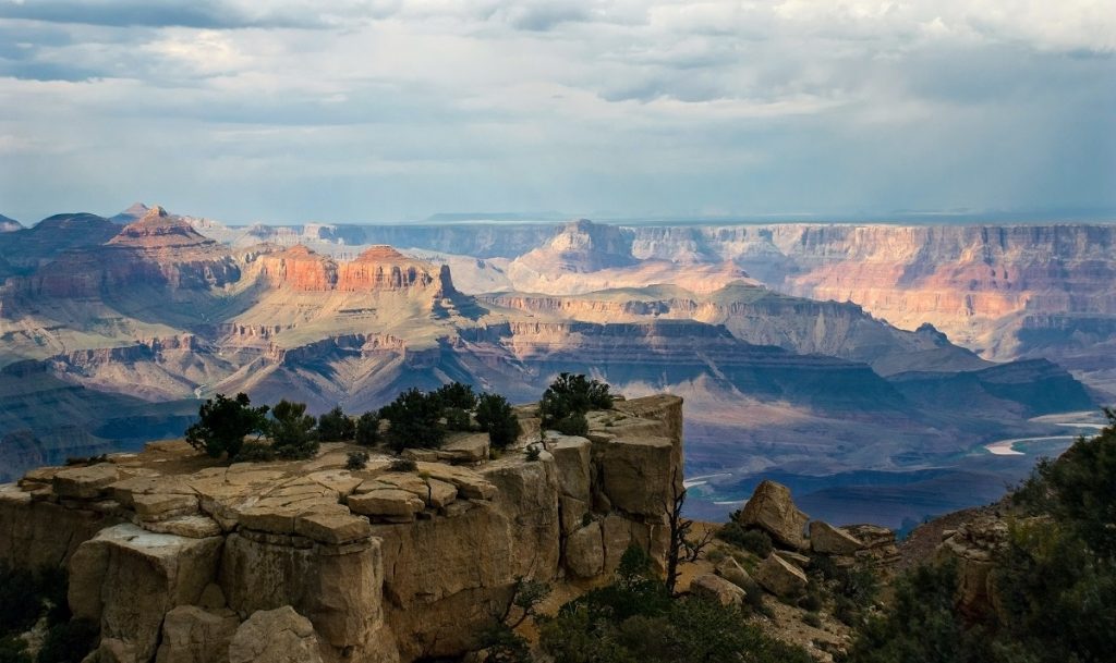 rock formation with mountains in background during daytime