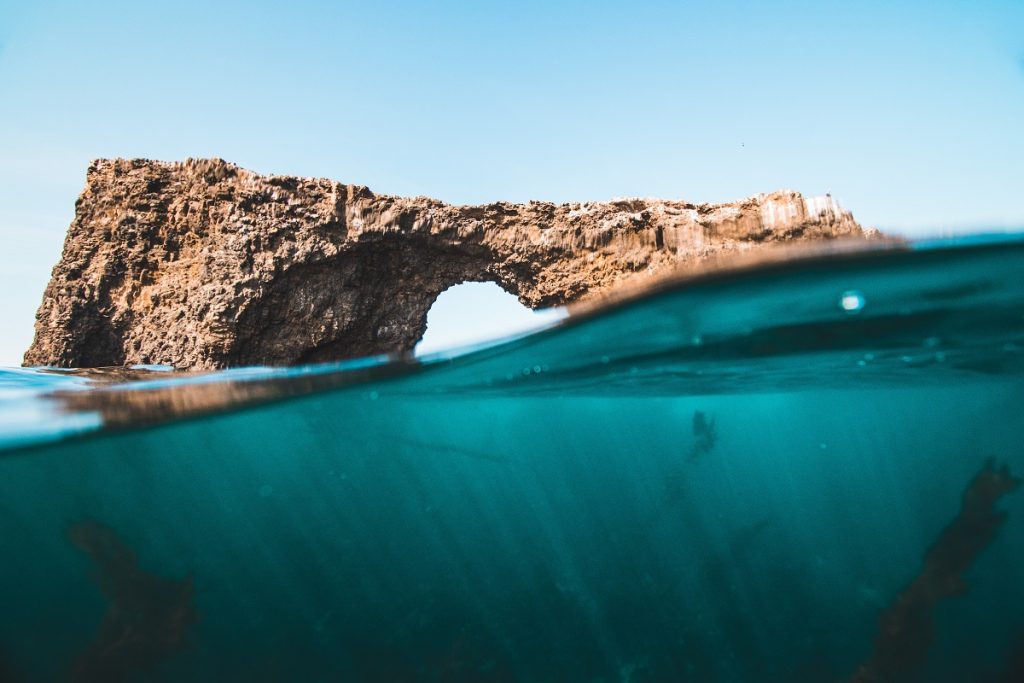 brown rock formation over body of water