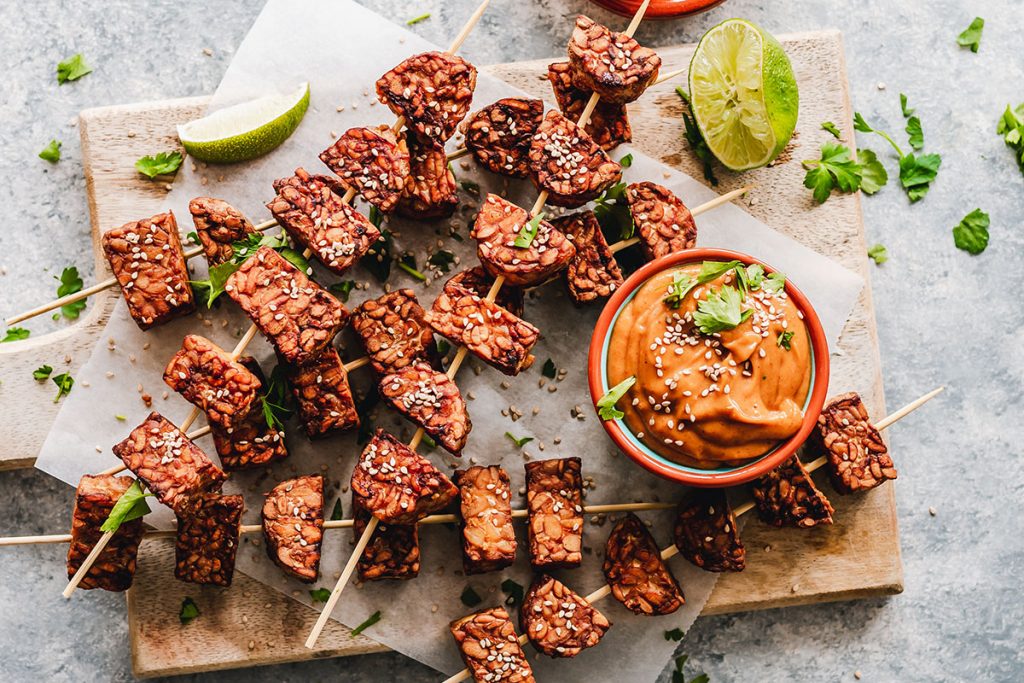 brown tempeh on skewers with lemon