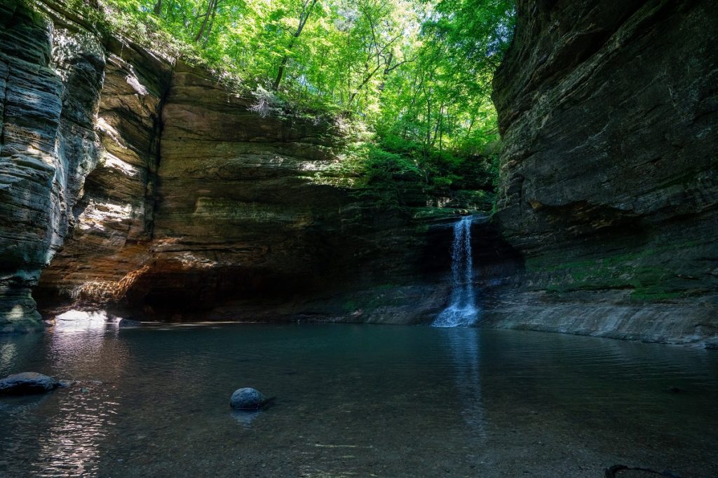 brown rock formation on river with waterfall