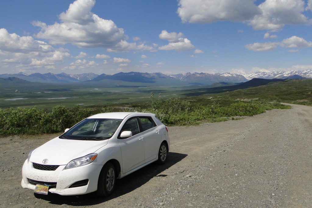 white car at the road near mountains