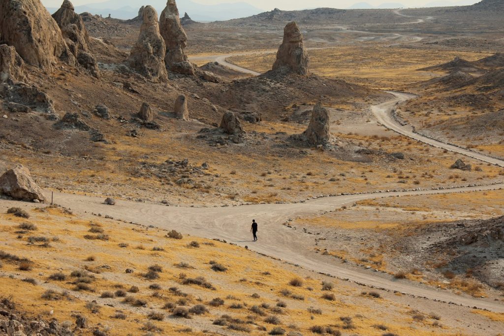 dirt roads next to brown rock formations