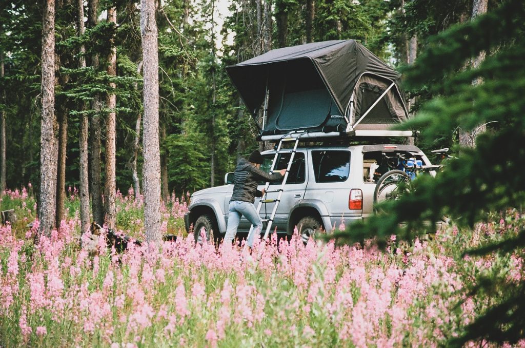 woman in KÜHL Spyfire Hoody climbing in car roof tent in the outdoors