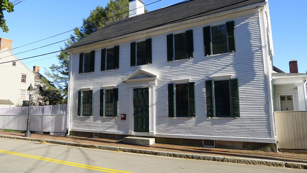 white building with dark green windows and door 