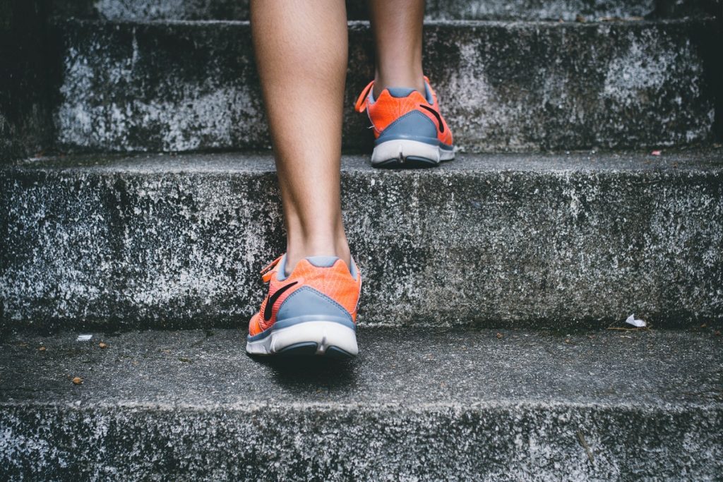 girl in orange shoes climbing gray stairs