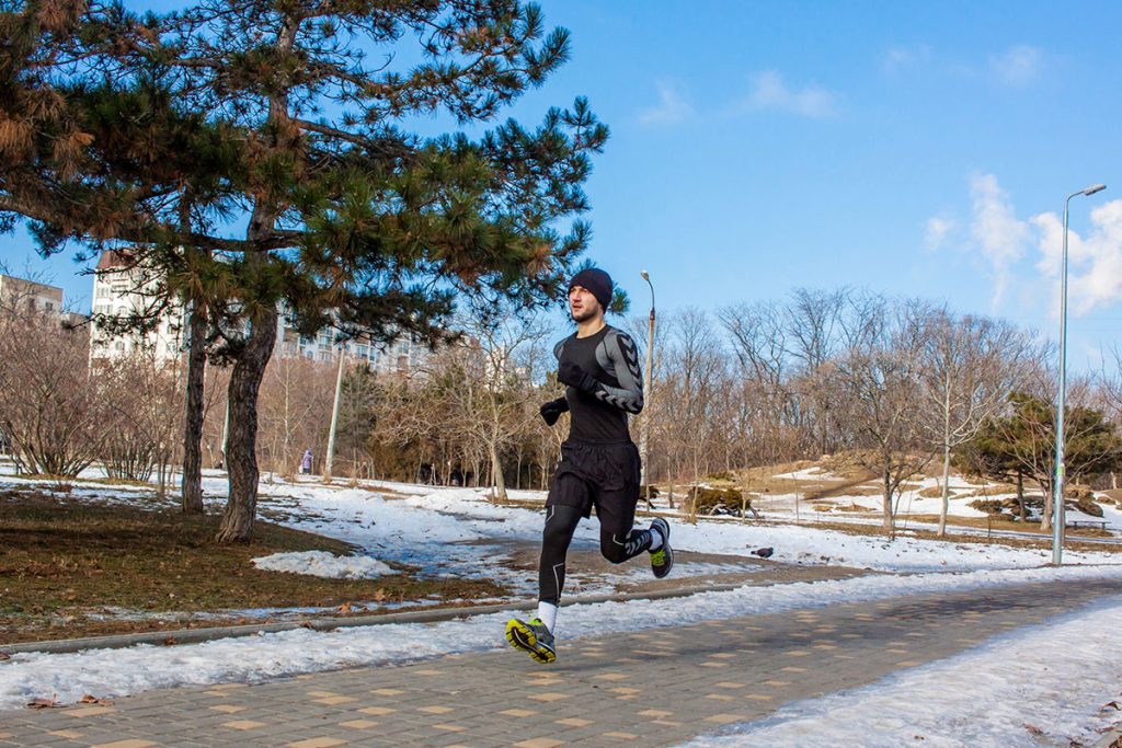 young runner training outdoor in winter park